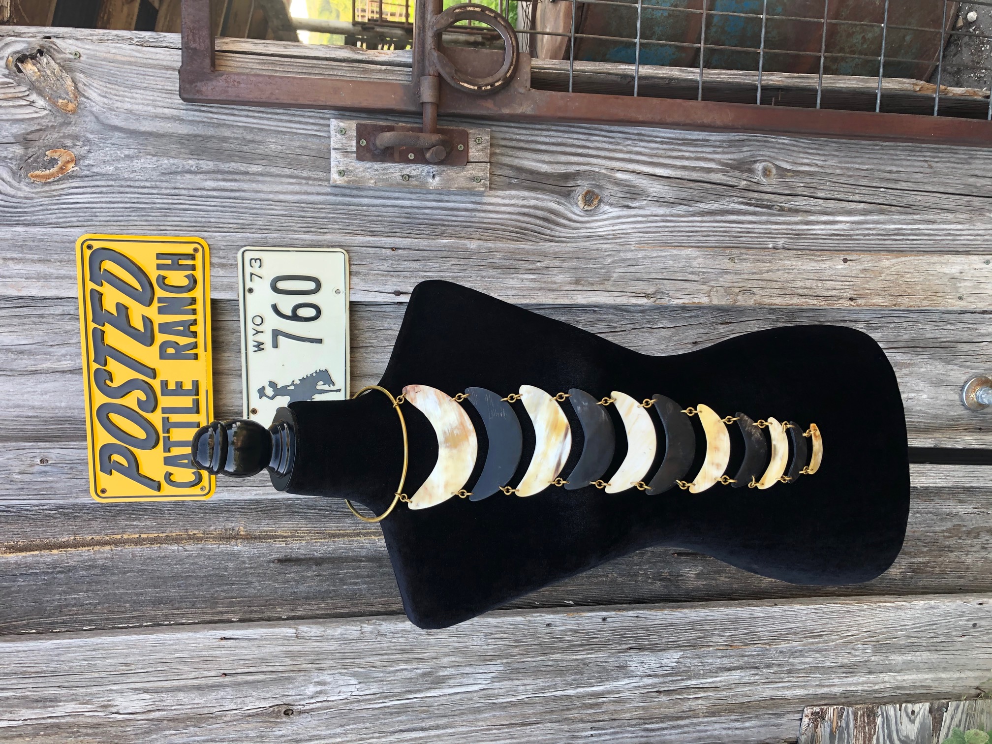 # Vintage Moon Phase Necklace

This is a long graduated crescent moon phase necklace featuring alternating polished bone or mother-of-pearl and black resin crescents connected with gold-tone chain links, circa 1970s-1980s bohemian style. The piece displays nine moon phases in descending size order, creating an elegant celestial-themed pendant perfect for astrology enthusiasts. The necklace combines natural and synthetic materials with warm metallic accents, exemplifying the witchy, New Age aesthetic popular during the late 20th century.